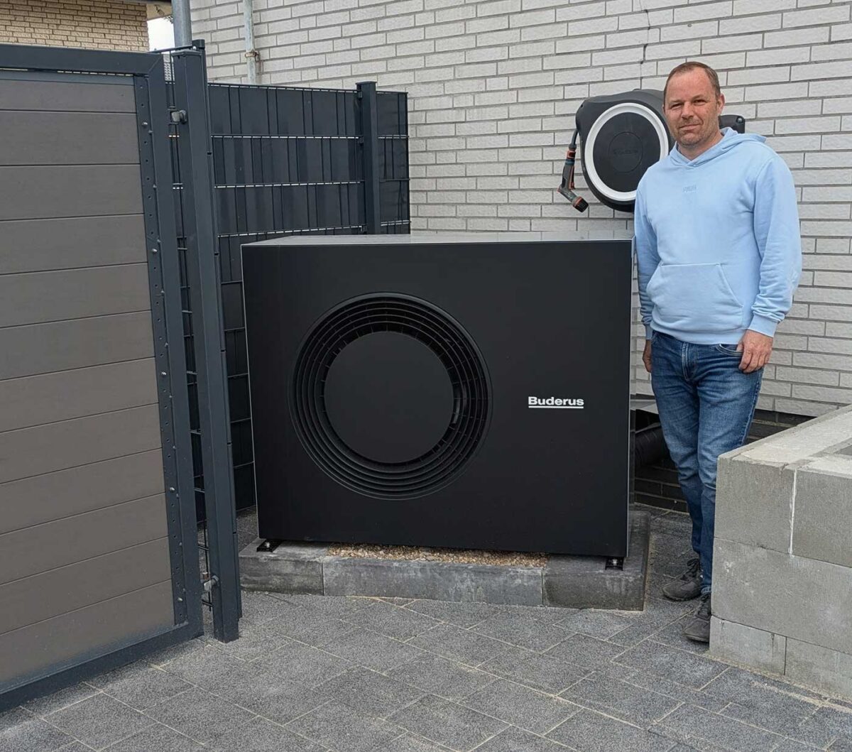 Arne aus Schiffdorf neben seiner montierten Buderus-Wärmepumpe